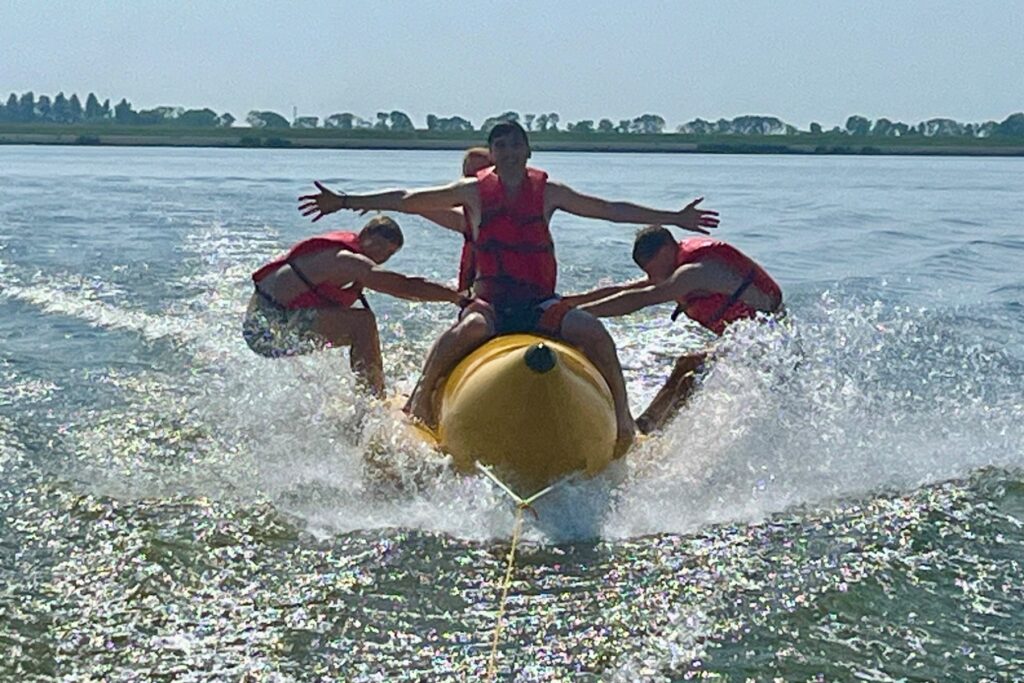 Groep geniet van bananenboot activiteit tijdens zeilweek op het IJsselmeer